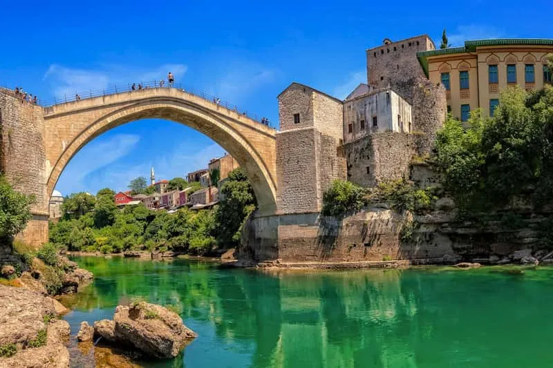 Group tour bus in Mostar with the iconic Old Bridge in the background on a Medjugorje tour from Dubrovnik