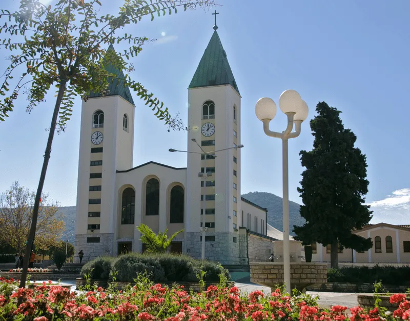 St. James Church in Medjugorje with pilgrims gathered outside on a guided day tour from Dubrovnik