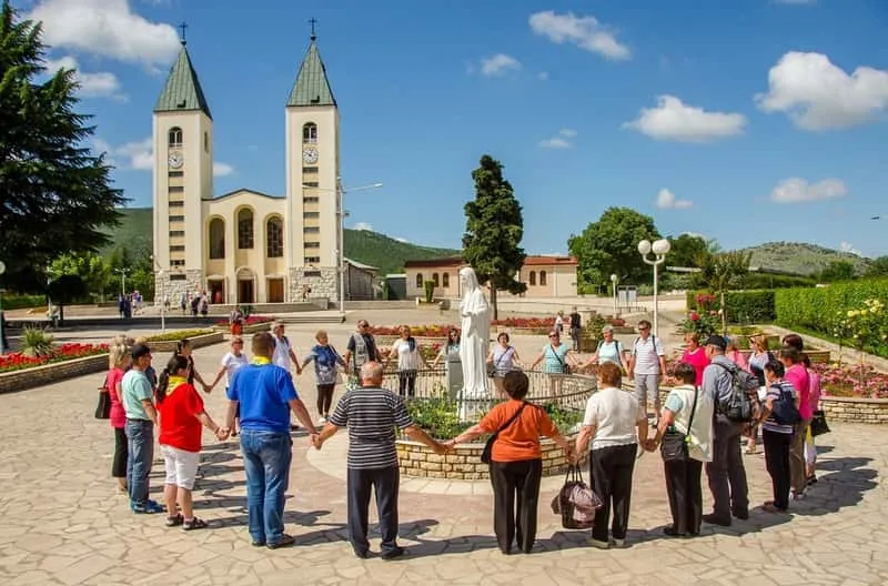 Pilgrims praying at the Medjugorje shrine on a full-day tour from Sarajevo through Bosnia and Herzegovina